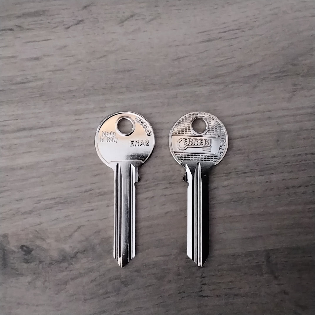 Two silver keys on a wooden surface